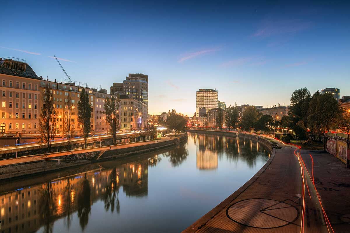 Blick auf die ruhige Stadtlandschaft am Abend mit reflektierenden Lichtern im Wasser
