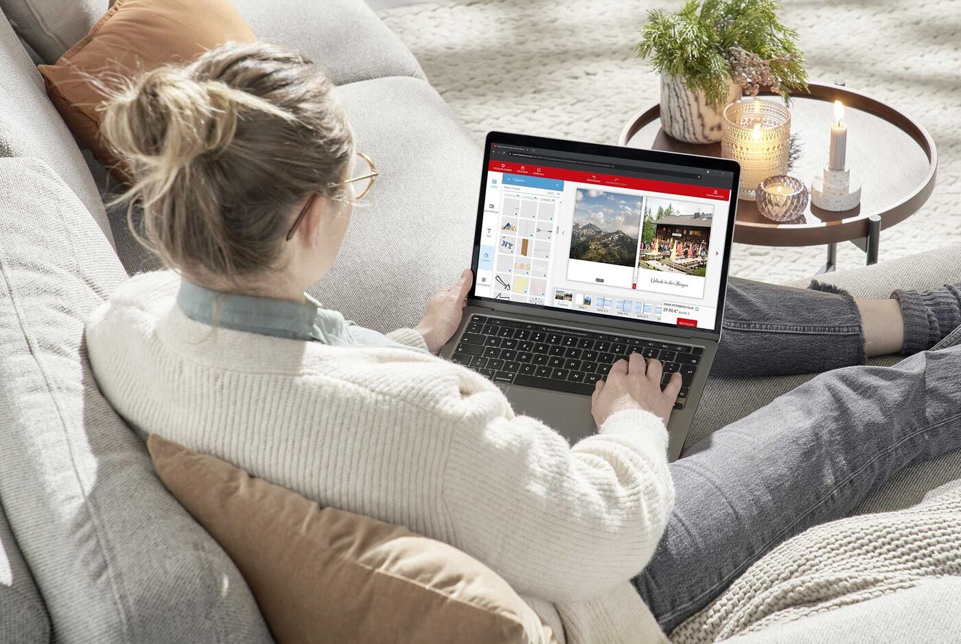 Eine Frau sitzt auf dem Sofa und gestaltet Fotos auf ihrem Laptop.