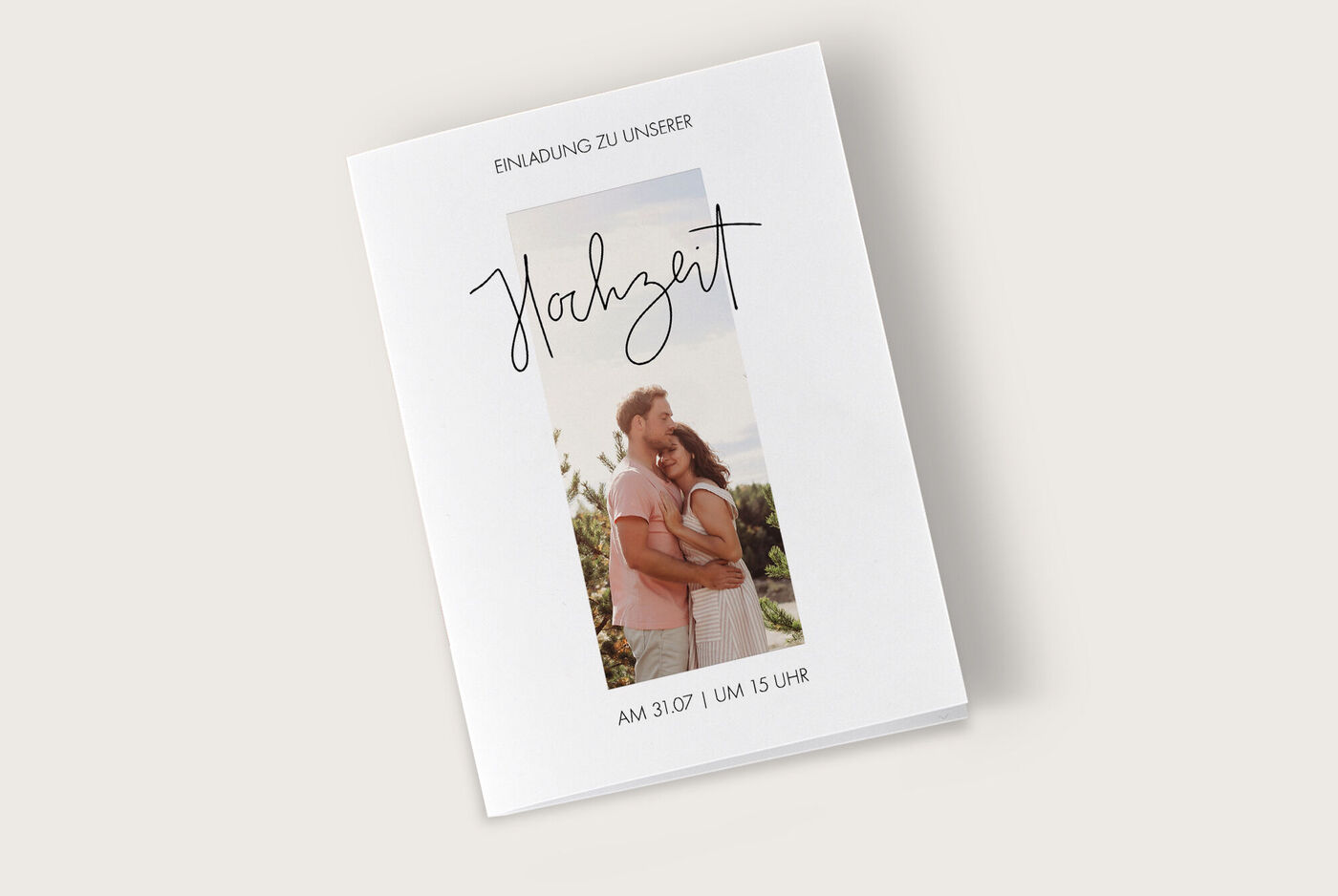 Einladungsdesign für eine Hochzeit mit romantischer Schriftart und einem Portrait-Paar im Hintergrund