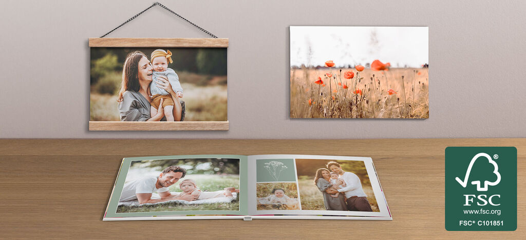 Familienfotos in einem CEWE Fotobuch & Wandbildern auf einem Tisch