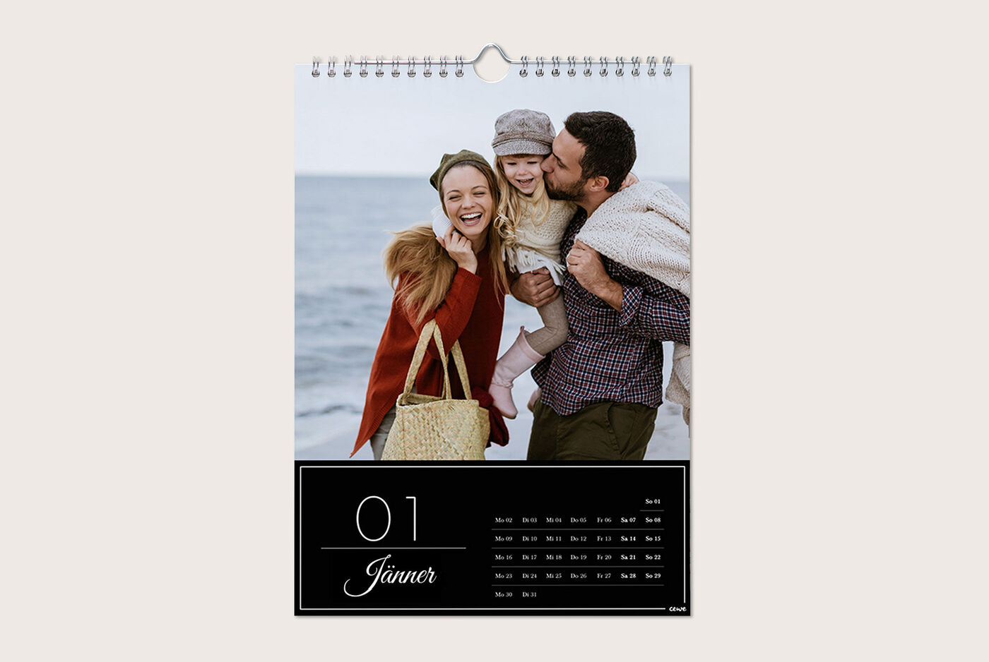 Familie am Strand, lachend und gemeinsam, mit Kalenderblatt für Januar im Vordergrund