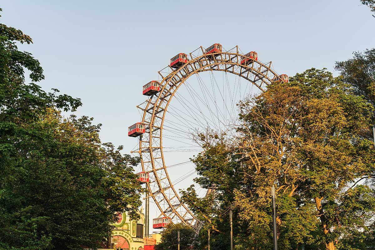 Riesenrad umgeben von Bäumen im Sonnenlicht