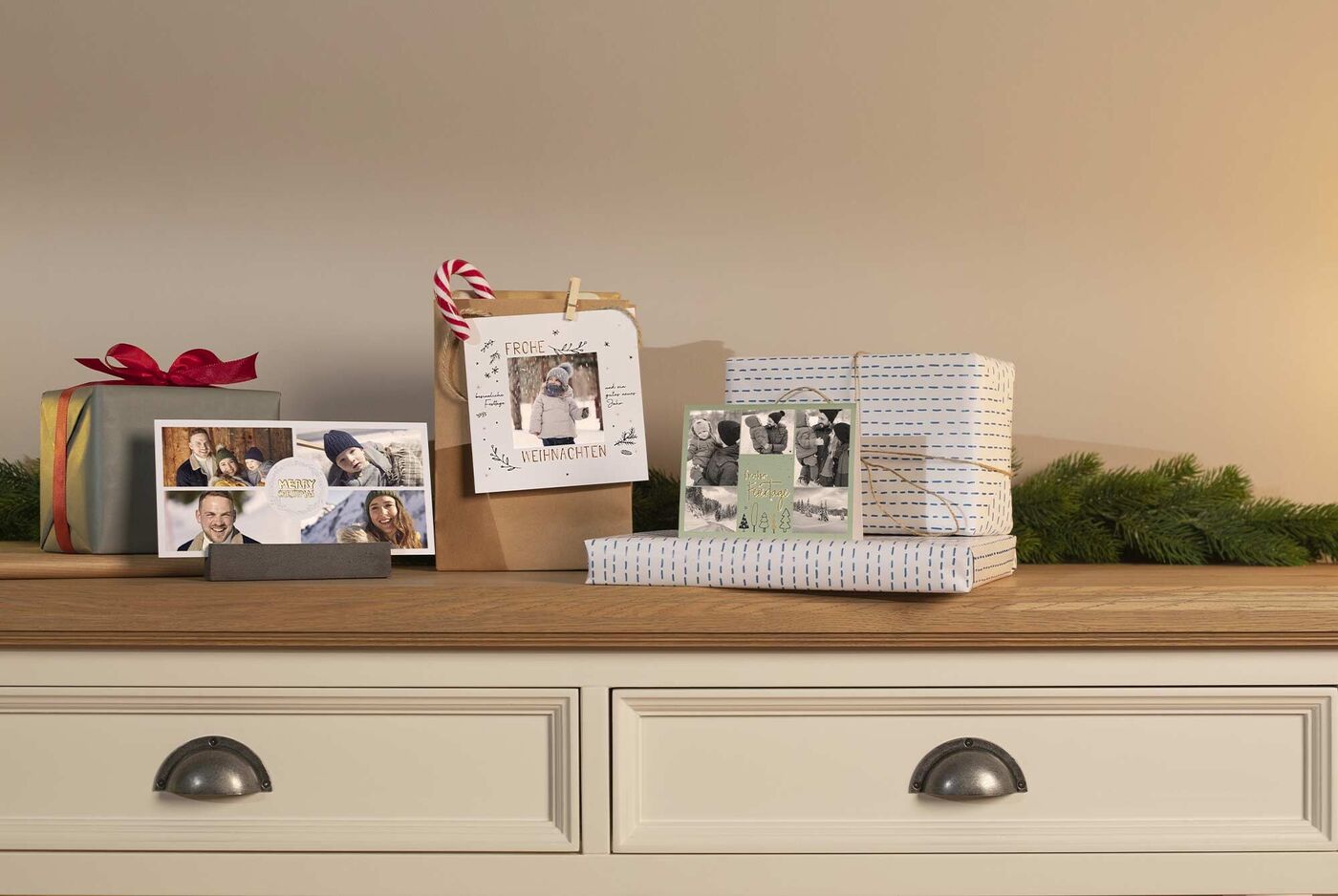 Wundervolle Geschenke und Fotos auf einer Holzkommode dekoriert mit verschiedenen Weihnachtskarten