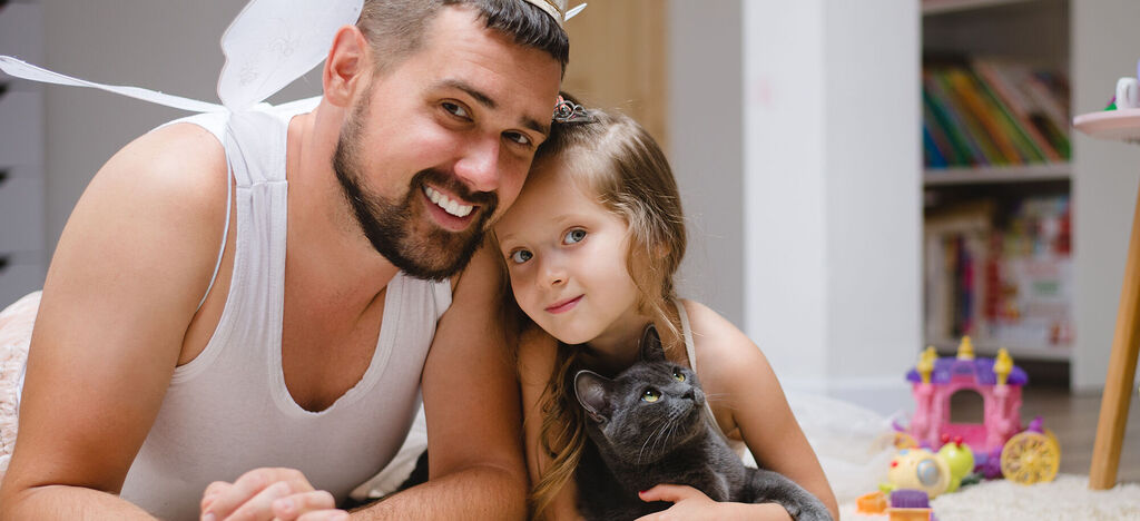 Familie entspannt mit Katze auf dem Boden. Wundervolle Momente voller Liebe.