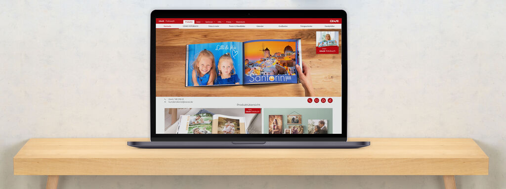 Laptop auf einem Tisch zeigt die CEWE Website mit Fotobüchern