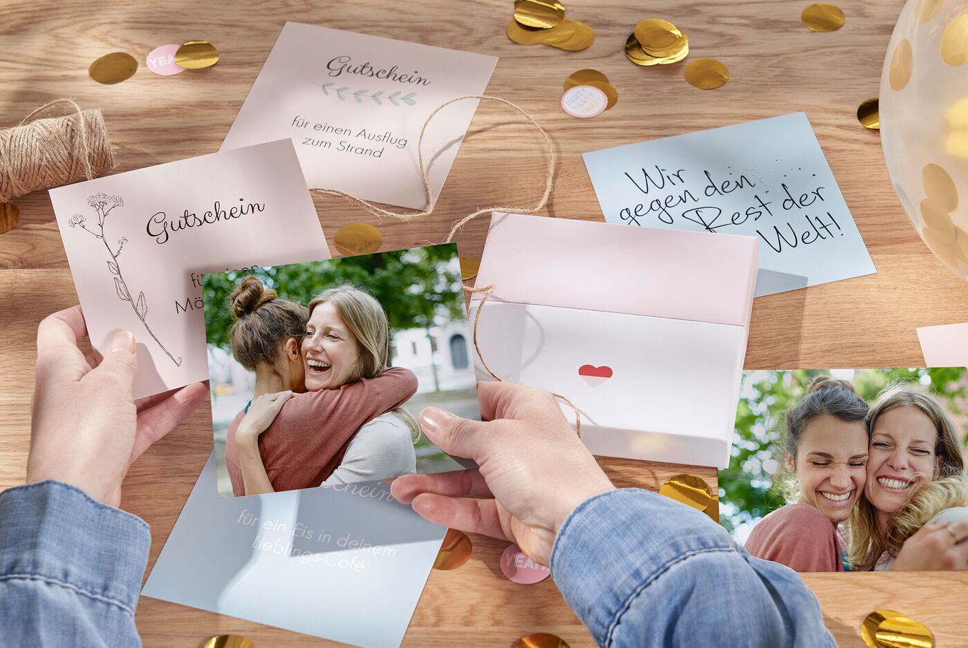Eine Person hält Fotos und Geschenkkarten in einer fröhlichen Umgebung. Gestaltet mit CEWE Grußkarten.