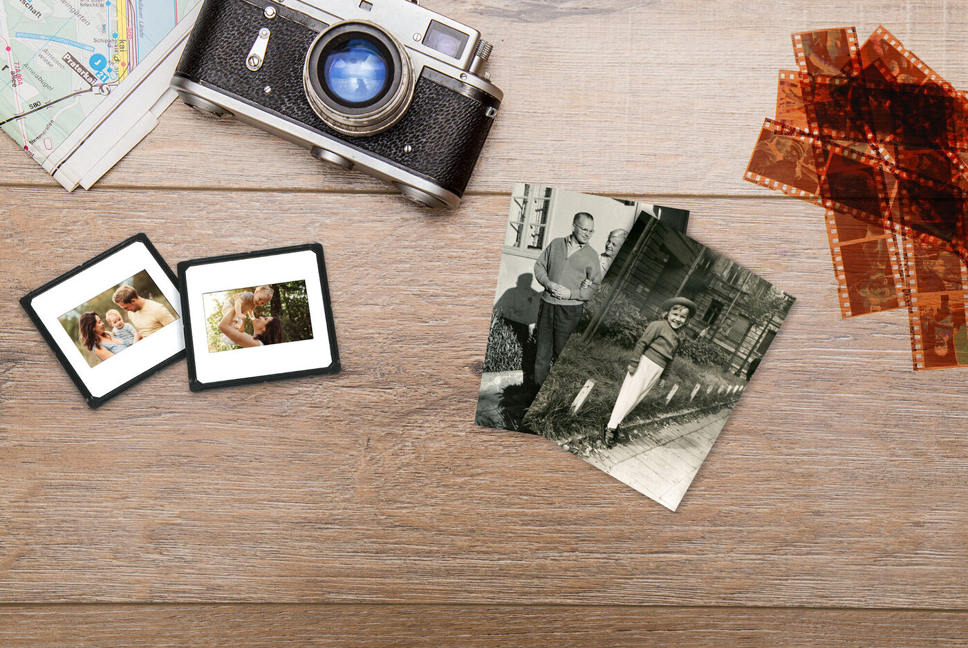 Altes Foto von einer Familie auf einem Tisch, umgeben von einer Kamera und Bildern