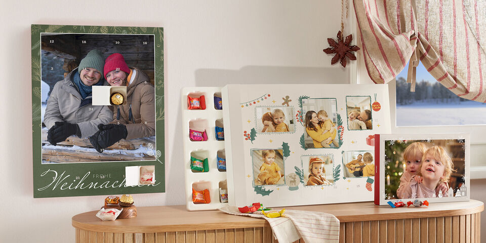 Die Auswahl von Foto-Adventskalendern von CEWE gefüllt mit Schokolade in verschiedenen Formaten und mit Familienfotos in einem Wohnzimmer