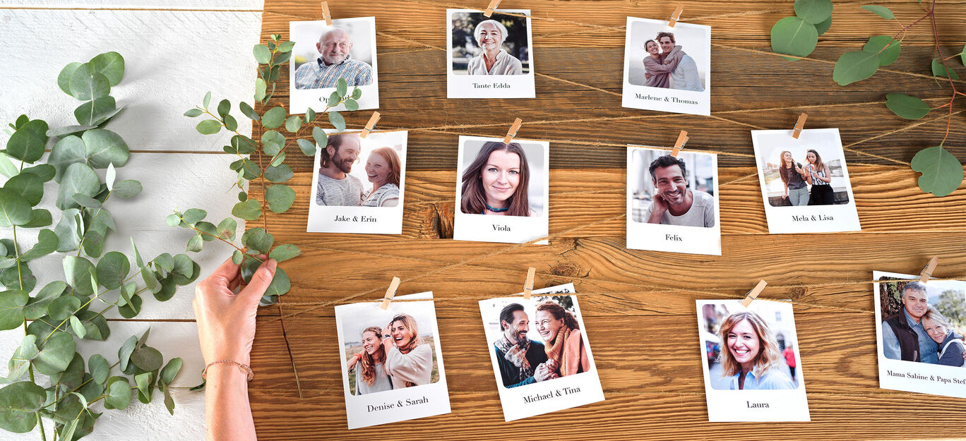 Eine Holzwand mit Fotos von Freunden und Familie, die mit Wäscheklammern aufgehängt sind.