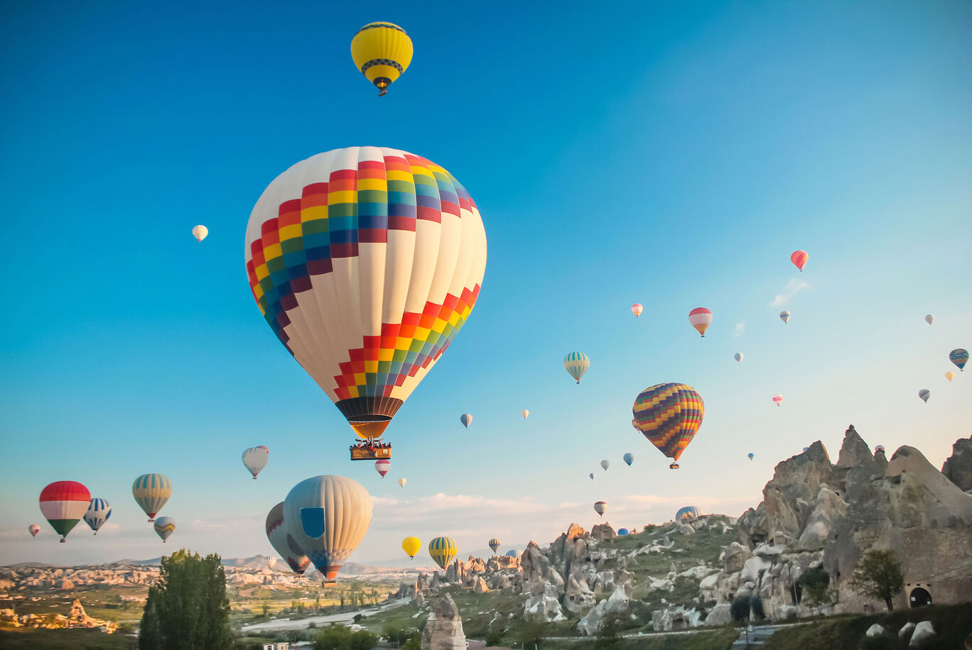 Bunte Heißluftballons steigen in den blauen Himmel über einer wundervollen Landschaft auf