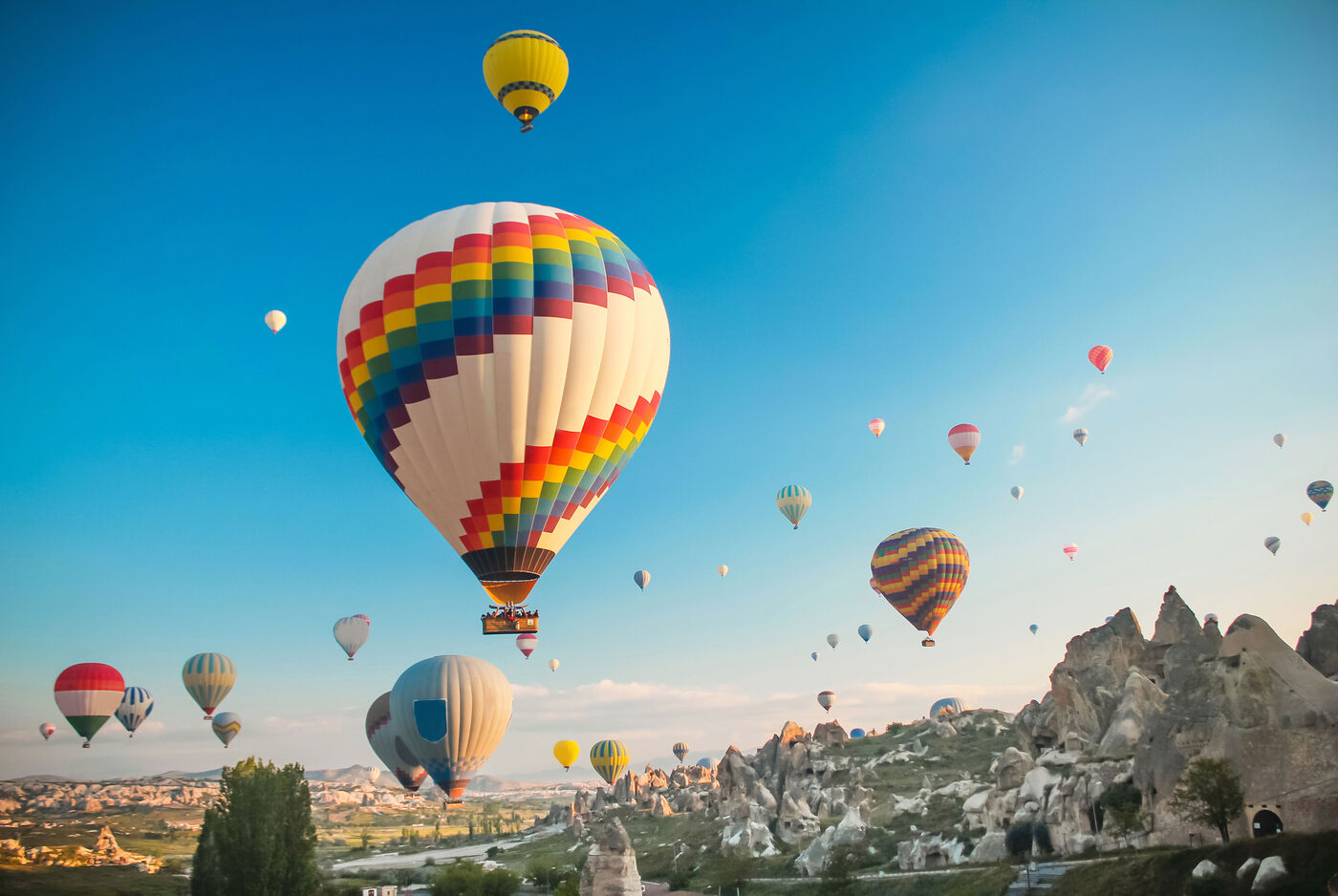 Bunte Heißluftballons steigen in den blauen Himmel über einer wundervollen Landschaft auf