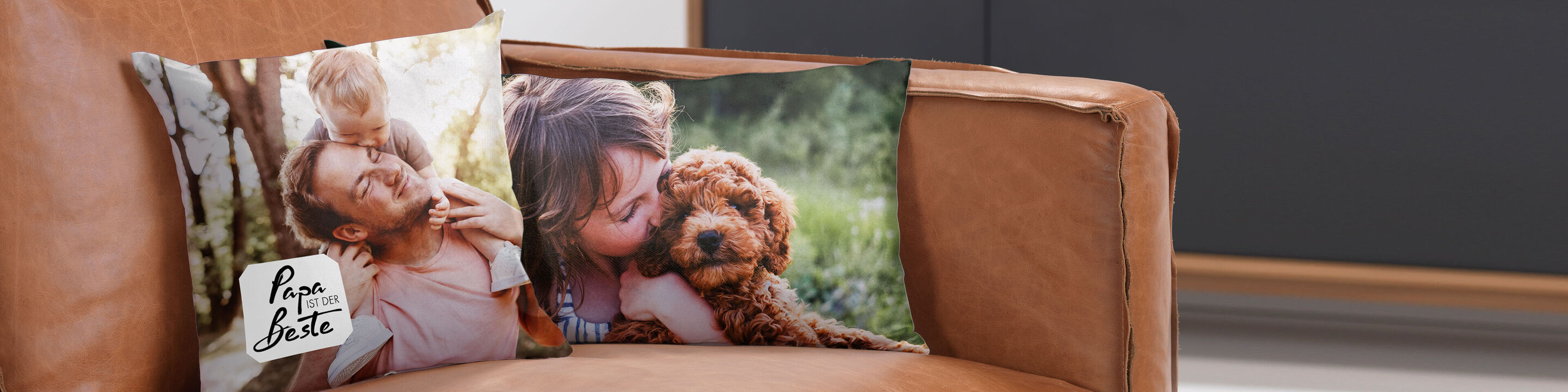 Zwei personalisierte Kissen auf einer Couch, eines zeigt einen lieben Moment mit Hund und einer Person, das andere hat eine liebevolle Botschaft.
