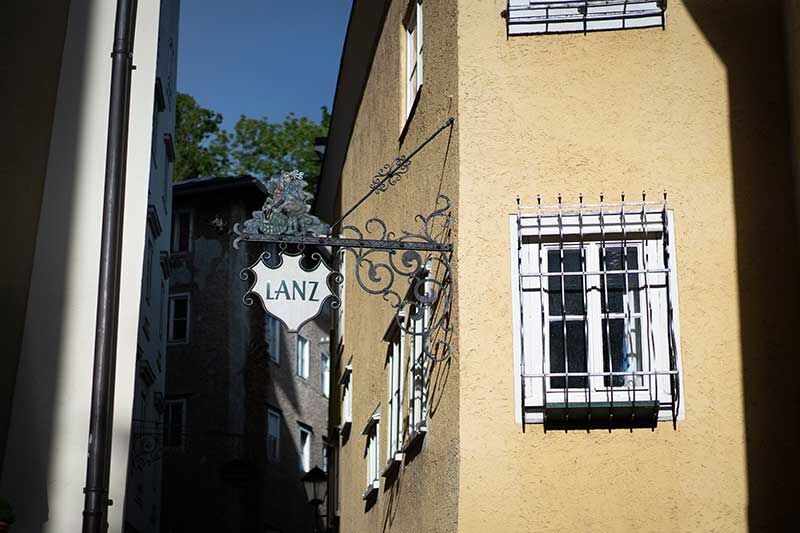Ein gelbes Gebäude mit einem Schilderrahmen "LANZ", das an einer Ecke steht