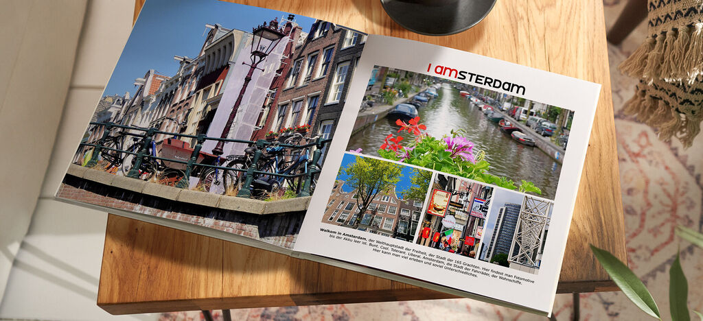 Offenes CEWE FOTOBUCH mit Amsterdam-Motiven auf einem Tisch