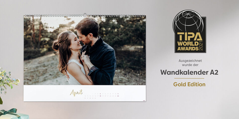 Ein Fotokalender im A2-Format mit Goldveredelung an einer hellen Wand mit dem Logo der Auszeichnung des TIPA World Award 2021.