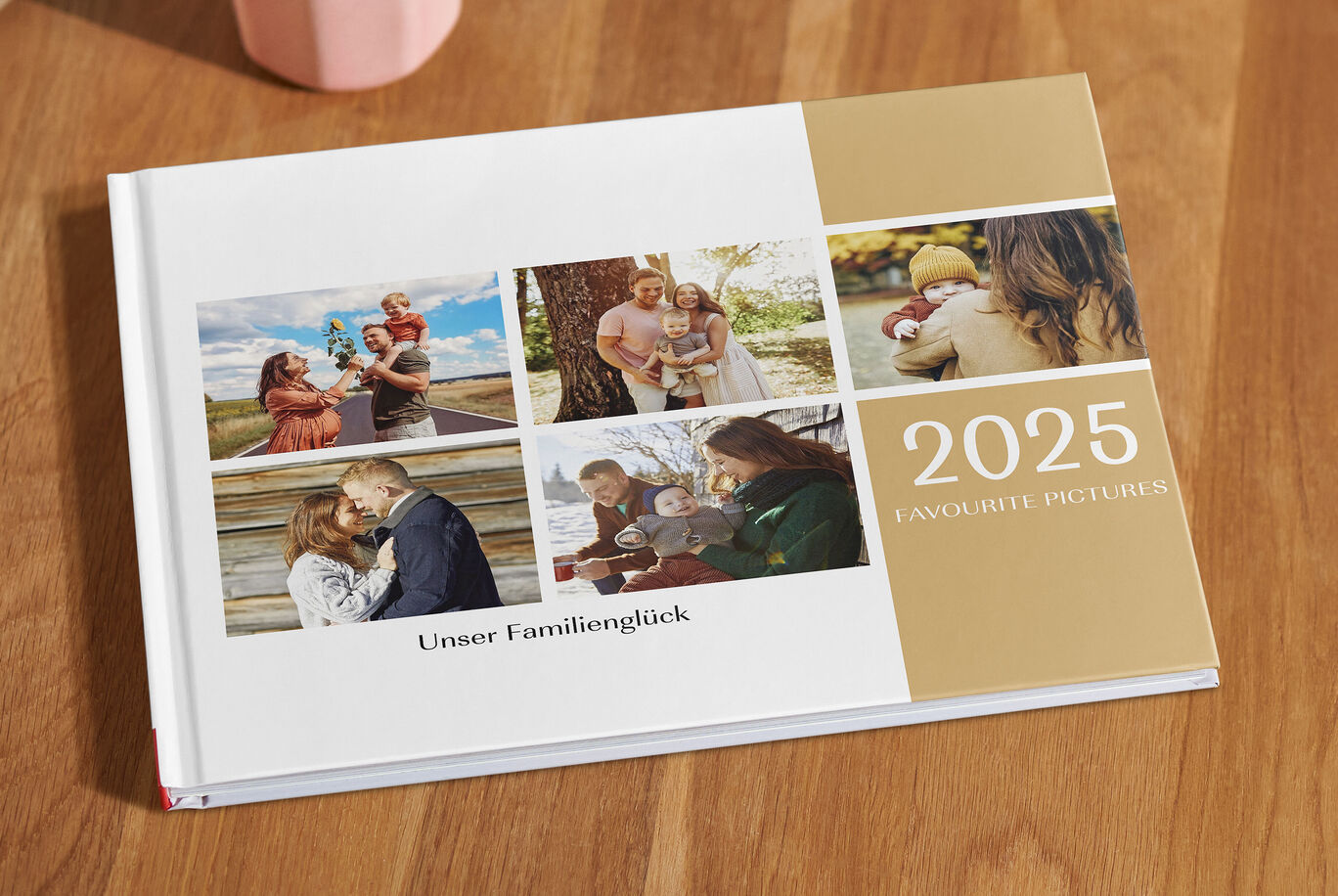 Ein liebevolles CEWE FOTOBUCH und dem Titel "Unser Familienglück 2025" auf einem Holztisch. Das Cover zeigt Familienfotos.