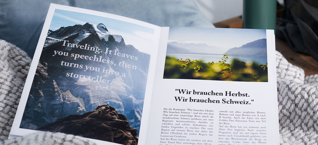 Aufgeschlagenes Fotobuch mit Landschaftsfotos und inspirierenden Texten