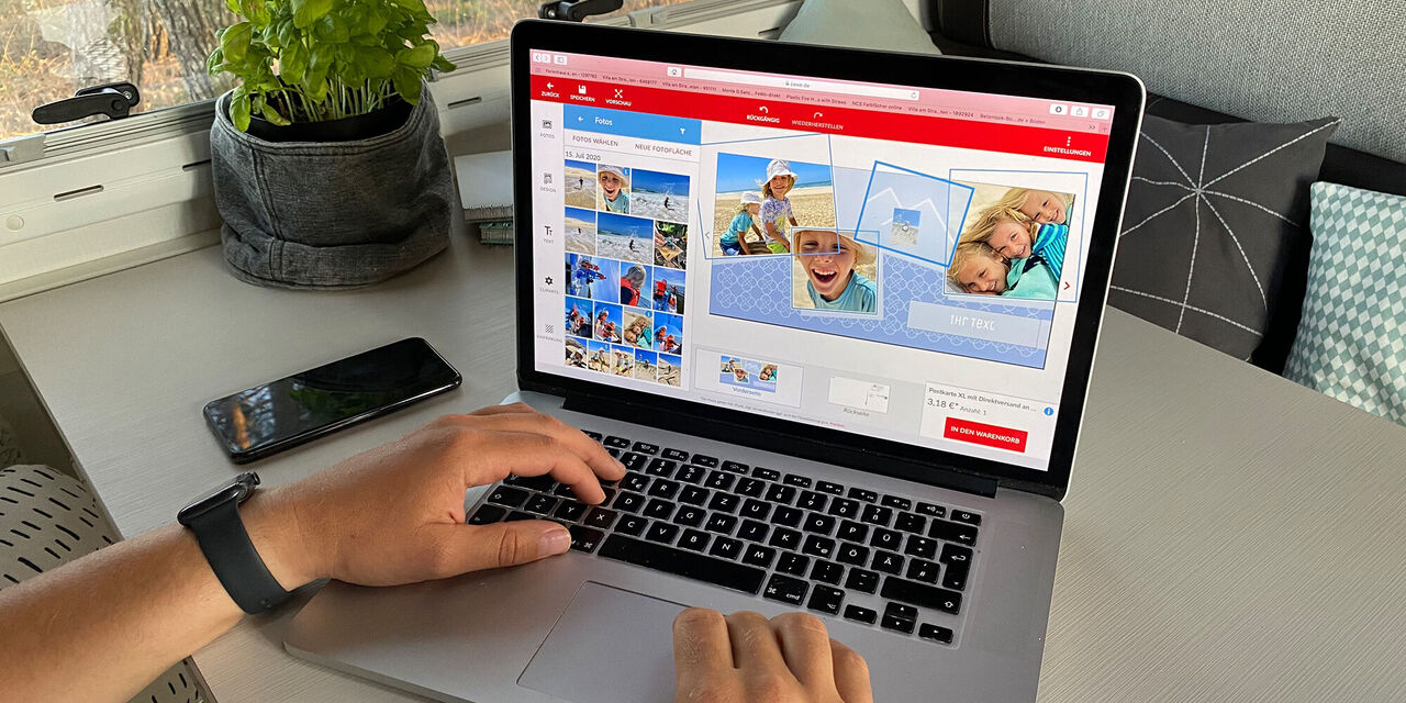 Person gestaltet ein CEWE FOTOBUCH am Laptop