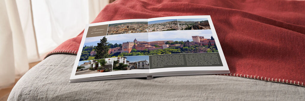 Offenes Fotobuch auf einem Bett mit Bildern von Urlaubserinnerungen