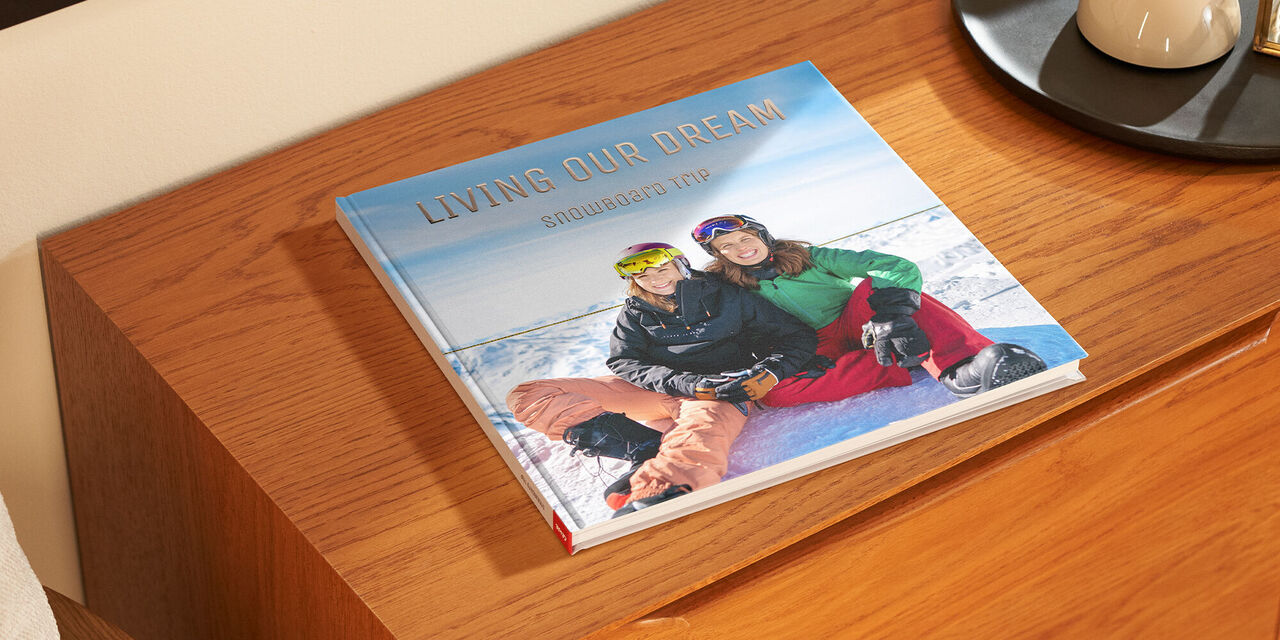 Ein offenes CEWE FOTOBUCH mit einem frostigen Outdoor-Motiv auf einem Tisch.