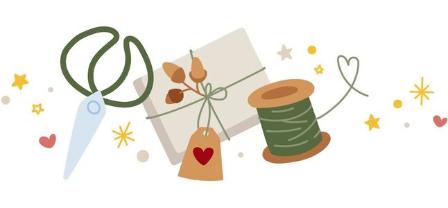 Bastelmaterialien: Schere, Garnrolle, Geschenktüte und Dekorationselemente in fröhlichen Farben