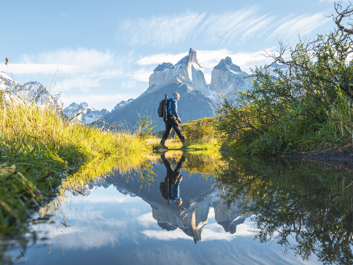 Wanderer spiegelt sich in einem kleinen Bergsee.