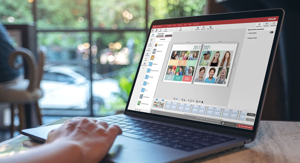 Eine Person gestaltet ein CEWE Fotobuch auf einem Laptop. Auf dem Bildschirm sind verschiedene Fotos zu sehen.