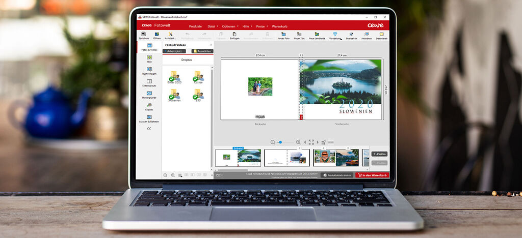 Laptop zeigt die CEWE FOTOBUCH Software mit Bildern von Landschaften.