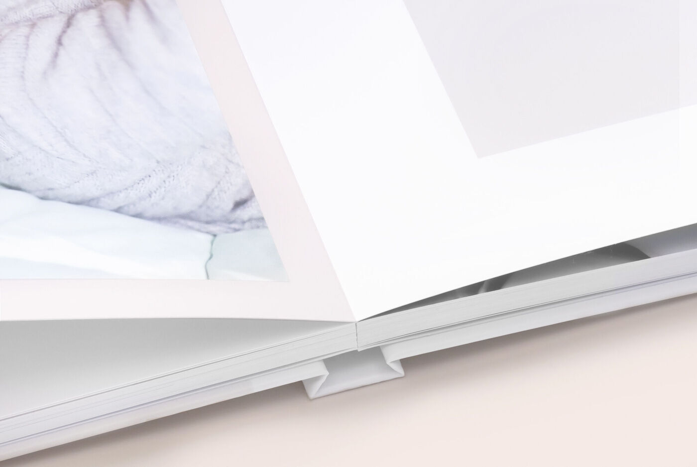 Nahaufnahme eines CEWE FOTOBUCH mit Fotopapier und Lay-Flat-Bindung ohne Mittelfalz und plan aufliegenden Seiten.