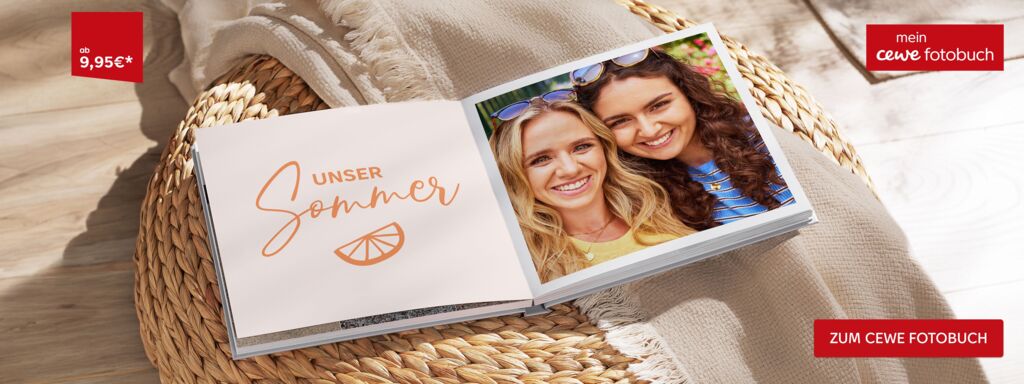 Ein aufgeschlagenes CEWE FOTOBUCH liegt auf einem Sessel mit Decke. Es sind zwei Frauen zu sehen und der Schriftzug "Unser Sommer"
