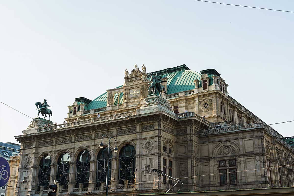Historisches Gebäude mit grünen Kuppeln und Reiterstatue