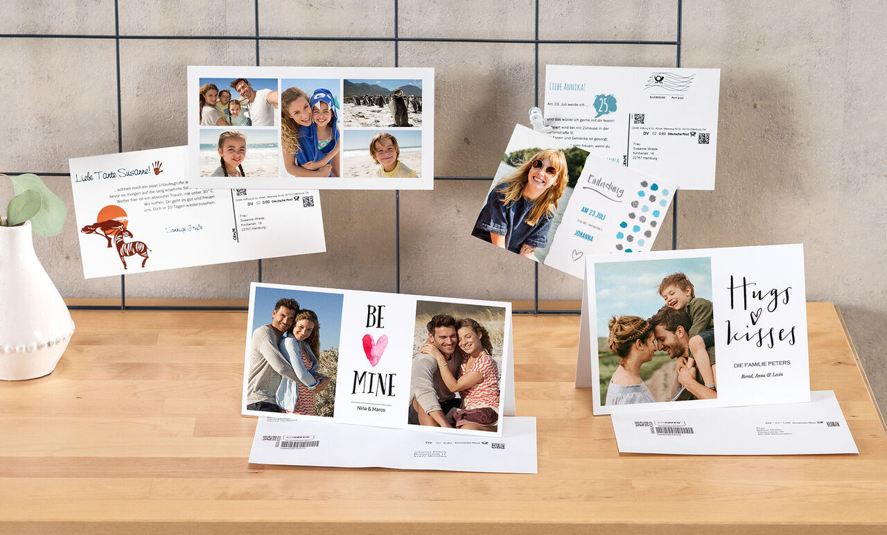 Vielfältige und kreative CEWE Grußkarten mit persönlichen Fotos und liebevollen Botschaften auf einem Holztisch