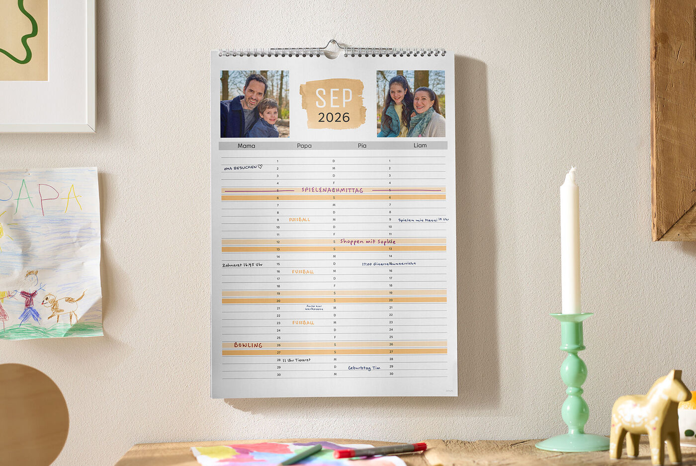 Ein CEWE Fotokalender als Familienplaner hängt an der Wand und zeigt oben drei persönliche Fotos sowie den Monat September.