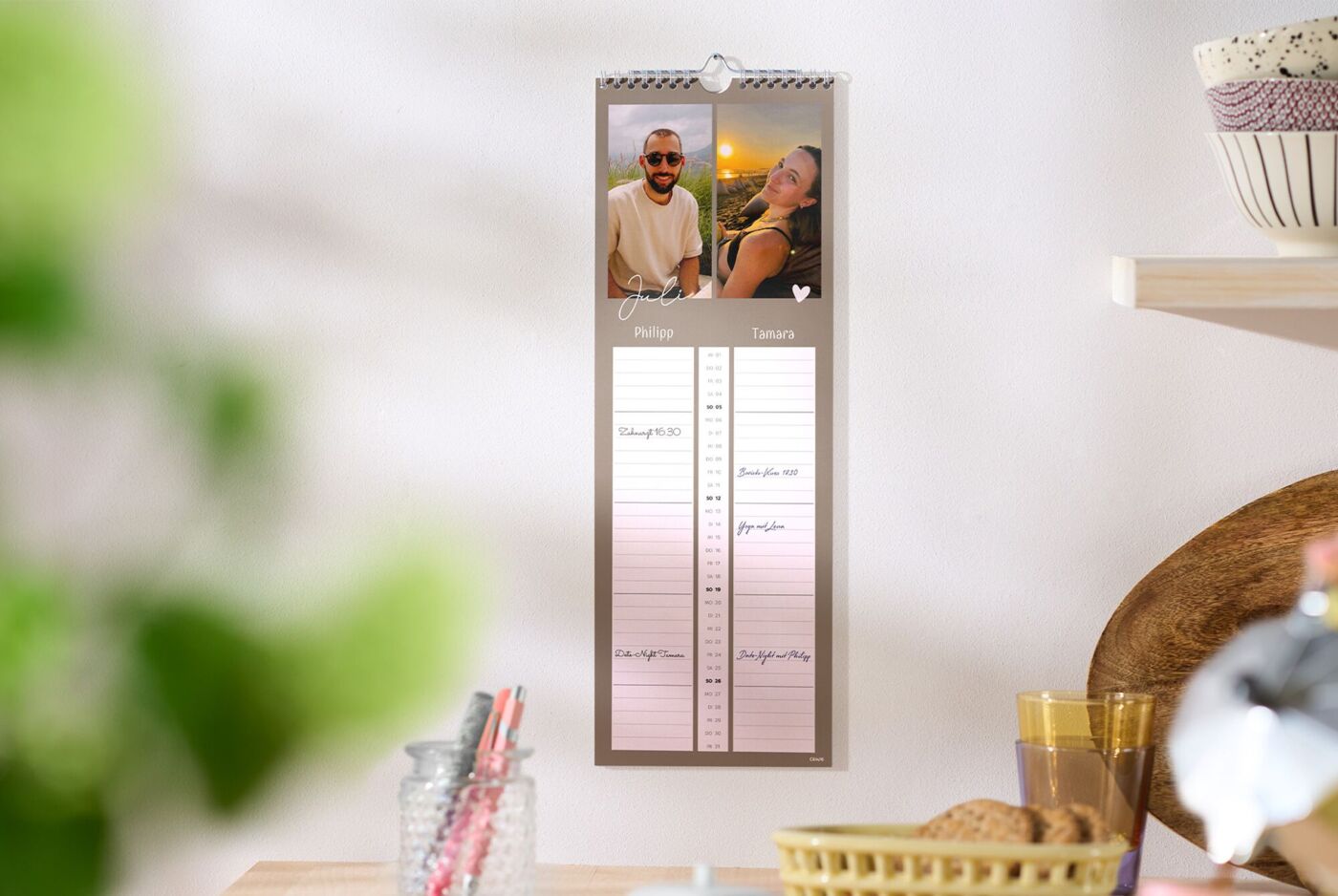 CEWE Fotokalender mit zwei Familienbildern hängt in heller Küche