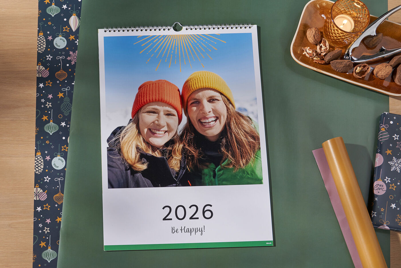 CEWE Fotokalender mit Strandmotiv und dem Titel 'Achtsam durch das Jahr' auf einem Holztisch mit Kalender-Geschenkverpackung